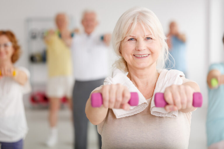 Senior,Woman,Exercising,With,Pink,Dumbbells,During,Classes